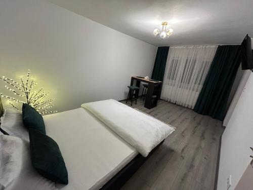 a bedroom with a white bed and a desk at Cozy Home Studio in Petroşani