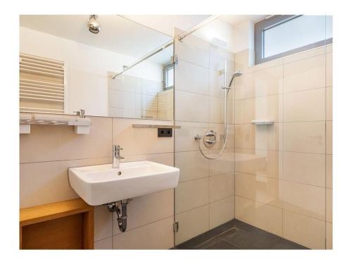 bagno bianco con lavandino e doccia di Holiday apartment Lore a Juliusruh
