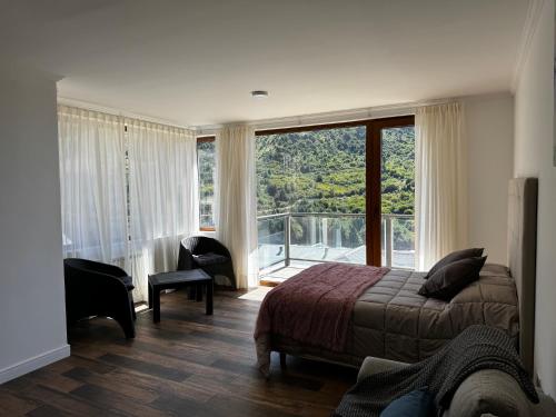 a bedroom with a bed and a large window at Sweet Catedral in San Carlos de Bariloche