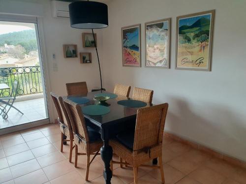 une salle à manger avec une table et des chaises et un balcon dans l'établissement Appartement Le Carthage, à Saint-Cyr-sur-Mer