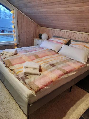 1 dormitorio con 1 cama con 2 toallas en Ferienhaus "Auszeit mit Herz" im Ferienpark Extertal - Kamin, Fass-Sauna, Massagesessel, en Extertal