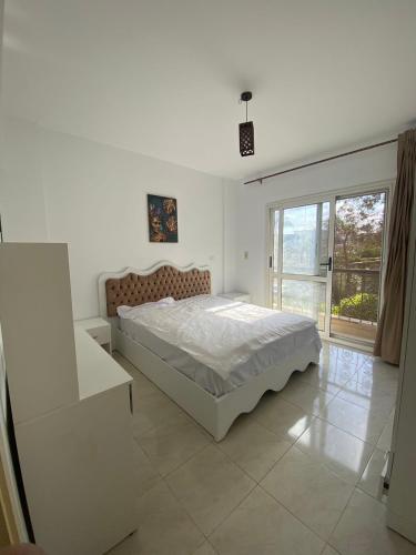 Habitación blanca con cama y ventana en 适家华人民宿 en El Cairo