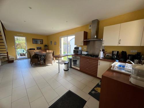 une cuisine avec un comptoir et une table à l'intérieur dans l'établissement Maison Sarzeau - Penvins, 300m des plages dans impasse au calme, reposant, à Sarzeau