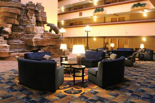 a hotel lobby with chairs and a stone fireplace at Holiday Inn Great Falls-Convention Center by IHG in Great Falls
