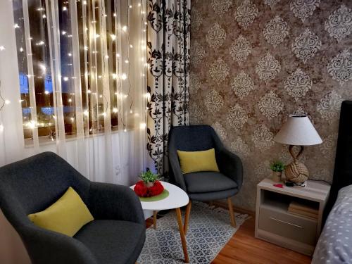 a living room with two chairs and a table at Apartment Pamporovo Palaсe A75 in Pamporovo