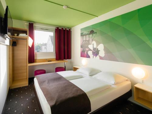 une chambre d'hôtel avec un lit et une fenêtre dans l'établissement B&B Hotel Bochum-Herne, à Herne