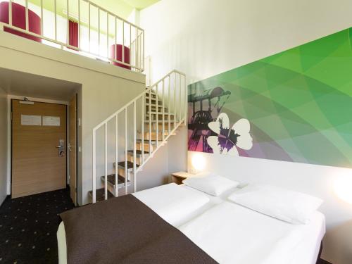 a bedroom with a white bed and a staircase at B&B Hotel Bochum-Herne in Herne