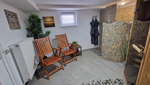 a bathroom with two chairs and a shower at Ferienhaus Guldner mit Terrasse, Garten und Sauna in Überherrn