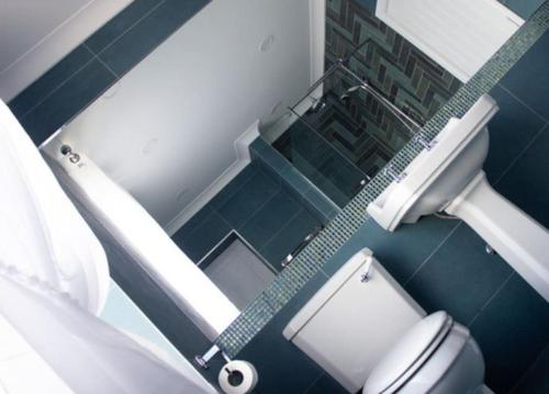 y baño azul con aseo y ducha. en Central village location en Lanchester
