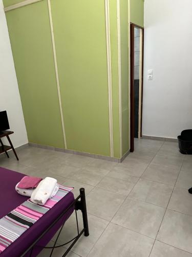 una camera con un letto e una parete verde di Lemonia a Megara