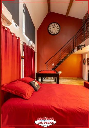 - une chambre avec un lit rouge et une horloge murale dans l'établissement LOFT LAS VEGAS Games / Casino / Babyfoot / Bar à jeux, à Saint-Étienne