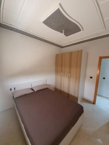 a bedroom with a large bed in the ceiling at Appartement Maghrib Jadid in Larache