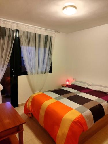 a bedroom with a bed and a table and a window at Apartamento con piscina in Benicarló