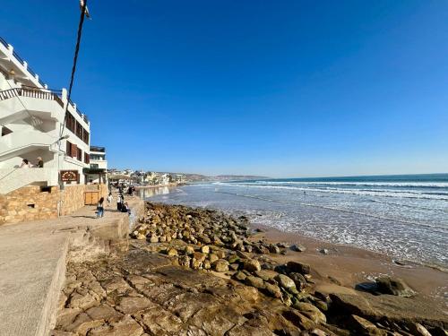 塔哈佐特La Banane House的一片拥有岩石和建筑的海滩和大海