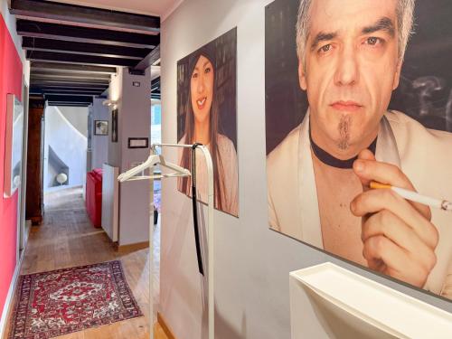 un bagno con il dipinto di un uomo che regge una sigaretta di T-Loft a Genova