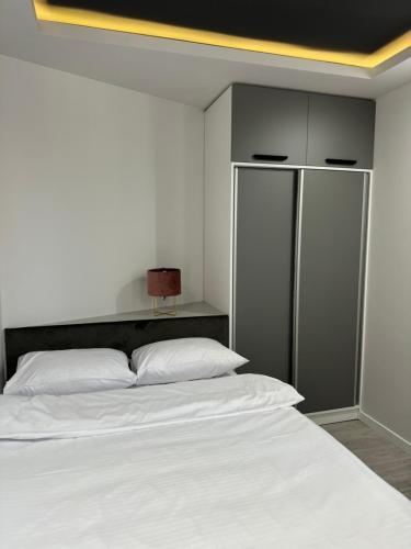 a bedroom with a large white bed and a cabinet at Mon Invite Hotel in Yerevan