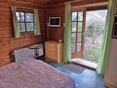 een slaapkamer met een bed, een bureau en een televisie bij Bed & Happiness in Wichmond