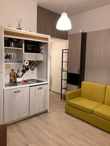un salon avec un canapé jaune et une cuisine dans l'établissement The Green House, à Rome