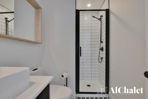 a bathroom with a shower with a glass door at Achille - Wooded with spa and sauna in Pont-Rouge