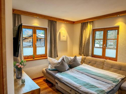 a living room with a couch and two windows at Ferienwohnungen Gastager Hof in Ruhpolding
