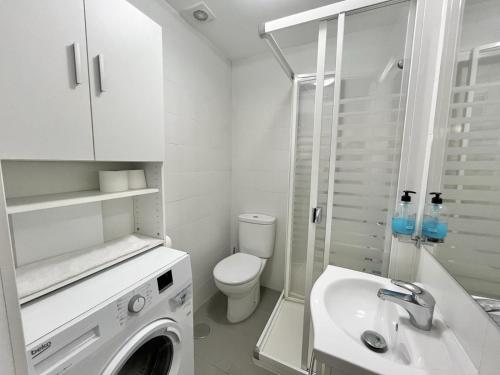 bagno bianco con lavatrice e lavandino di Apartamento la Soledad, junto al Alcázar a Toledo