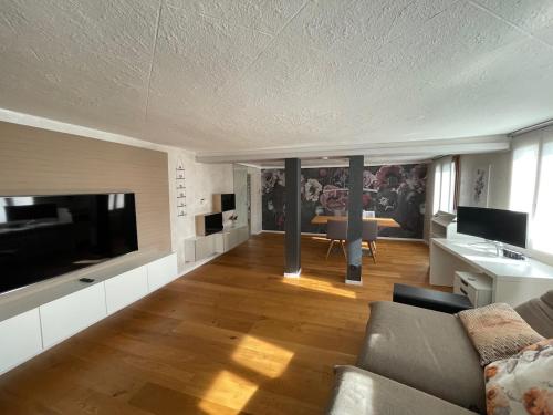sala de estar con TV grande y sofá en Schöne Wohnung in Feldkirch, en Feldkirch