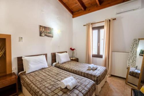 una camera d'albergo con due letti e una sedia di Casa Mavili, Top Location - Cozy Interiors a Rethymno