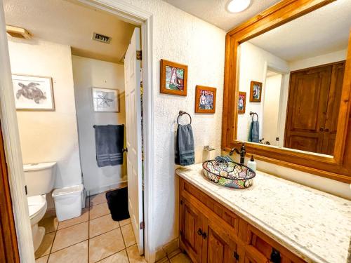 une salle de bain avec un lavabo, des toilettes et un miroir dans l'établissement Princesa de Penasco Condo C101 Sandy Beach Puerto Penasco, à Puerto Peñasco