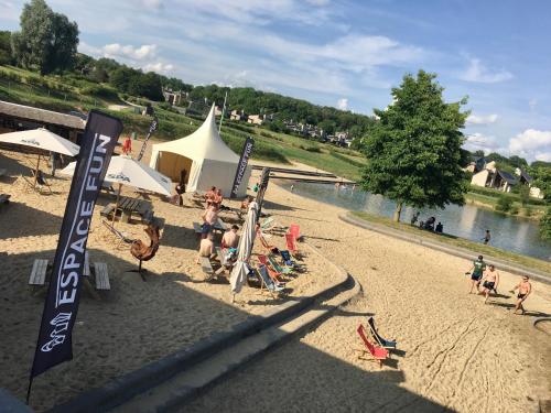 a group of people on a beach near a river at La ferme du Ravet - Gîtes aux Lacs de l'Eau d'Heure in Froid-Chapelle