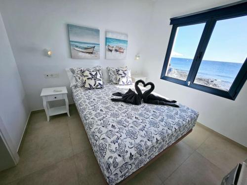 um quarto com uma cama e uma janela grande em Casa Playa Quemada junto al mar em Playa Quemada