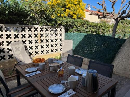 une table en bois avec des assiettes de nourriture dessus dans l'établissement Jolie maisonnette rénovée, à Saint-Cyprien