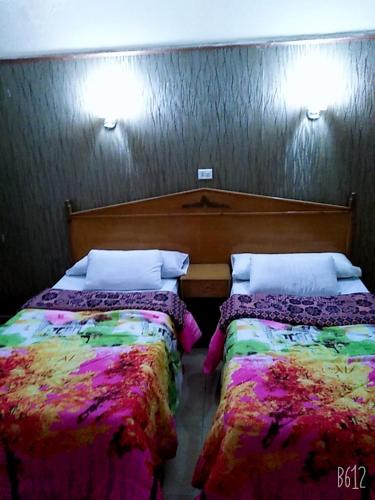 Queen Home Hotel في مرسى مطروح: سريرين يجلسون بجانب بعض في غرفة