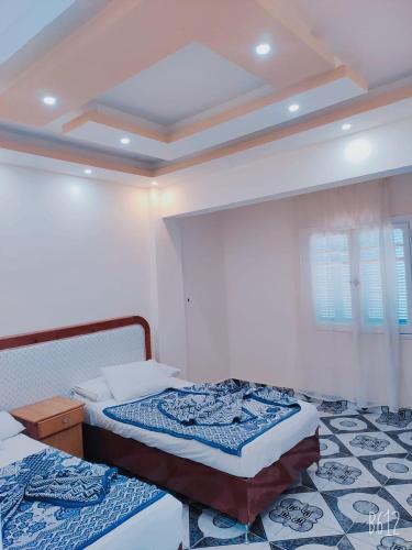 a bedroom with two twin beds and a ceiling at Queen Home Hotel in Marsa Matruh