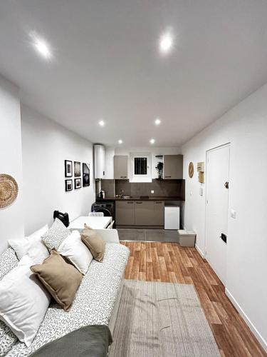 ein Wohnzimmer mit einem weißen Sofa und einer Küche in der Unterkunft Studio tout confort refait à neuf in Levallois-Perret