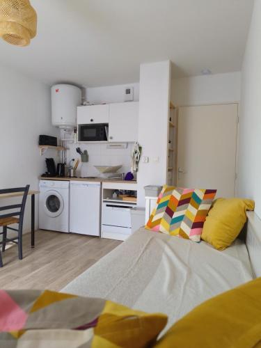 a white kitchen with a bed in a room at Studio avec grande terrasse gare Sud in Nantes