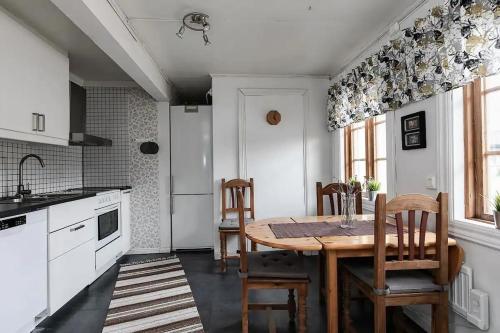 a kitchen with a wooden table and chairs at Grindstugan - Centralt och trevligt hus i Nora in Nora