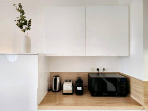 a microwave sitting on top of a kitchen counter at La Pause Dorée d'Anne-Sophie in Bruz