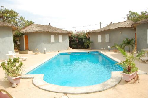 una piscina en un patio con 2 haciendas en Melia's hotel, en Sali Nianiaral