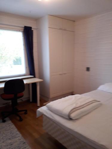 1 dormitorio con cama, escritorio y ventana en Majatalo, en Kuopio