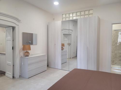 Habitación blanca con espejo y tocador en Domo Azuni en Sassari