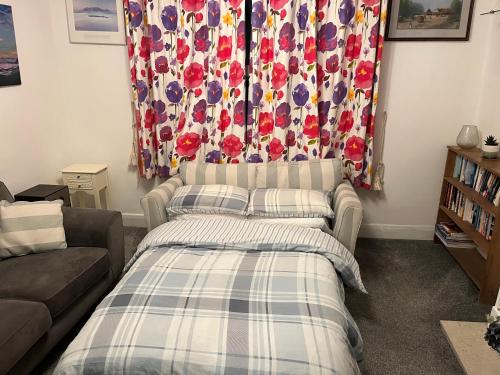 a living room with a bed and a couch at Lovely 1 bedroom flat in quiet Wimbledon in London