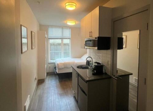 uma cozinha com um lavatório e uma cama num quarto em Pacific Trillium Studio, Wallingford 97 Walkscore em Seattle