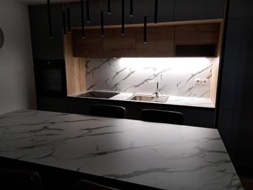 a kitchen with a marble counter top and a sink at Apartmani Vukadin in Vir