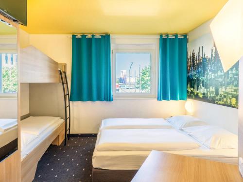 a hotel room with two beds and a window at B&B Hotel Ludwigshafen in Ludwigshafen am Rhein