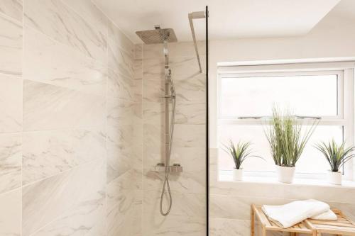 a shower in a bathroom with white marble at Stylish 3-Bed City Centre Home in Chester by 53 Degrees Property, Ideal for Groups, Private Parking! in Chester