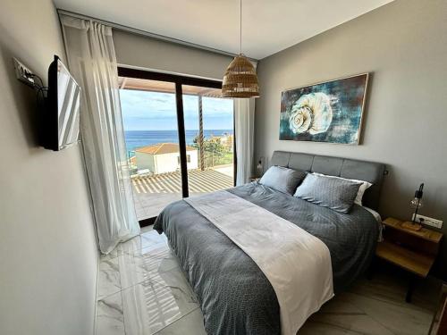 a bedroom with a bed and a view of the ocean at Βίλα -Θαλασσινή αύρα, 500μέτρα από την θάλασσα in Áyios Andónios