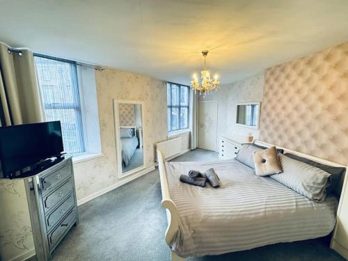 a bedroom with a large bed with a tv and a bed sidx sidx sidx at Riverside House, North Shields Fish Quay in North Shields