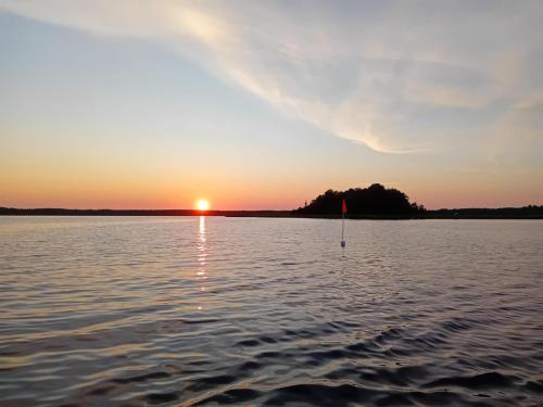 un coucher de soleil sur un corps d'eau dans l'établissement Romantiline ja privaatne talu Pädaste lahe ääres, à Pädaste