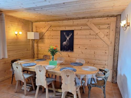 une salle à manger en bois avec une table et des chaises dans l'établissement La Coufa, spacieux Duplex en chalet, terrasse, jardin, vues montagnes, à La Giettaz