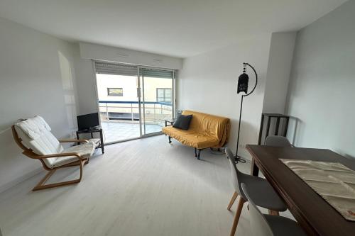 un salon avec un canapé, des chaises et une table dans l'établissement Spacieux Deux pièces en front de mer pour 4 personnes, à Agay